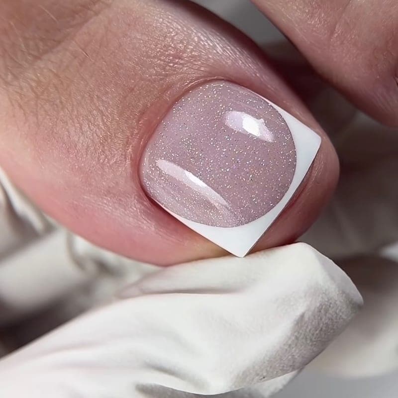 A toe with a sheer shimmer base and a white French edge